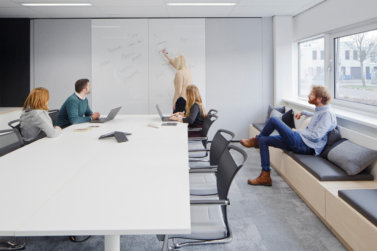 A sala de reuniões do escritório da Adecco em Amsterdam, além da mesa tradicional, apresenta assentos laterais com almofadas para favorecer a descontração. Crédito: Divulgação Officesnapshot