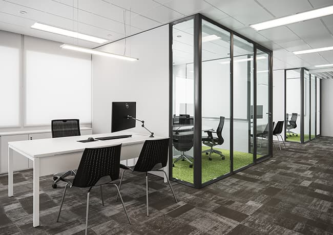 Nesse projeto com móveis corporativos da RS Design é possível observar as pequenas salas de reunião para encontros rápidos entre os pares.